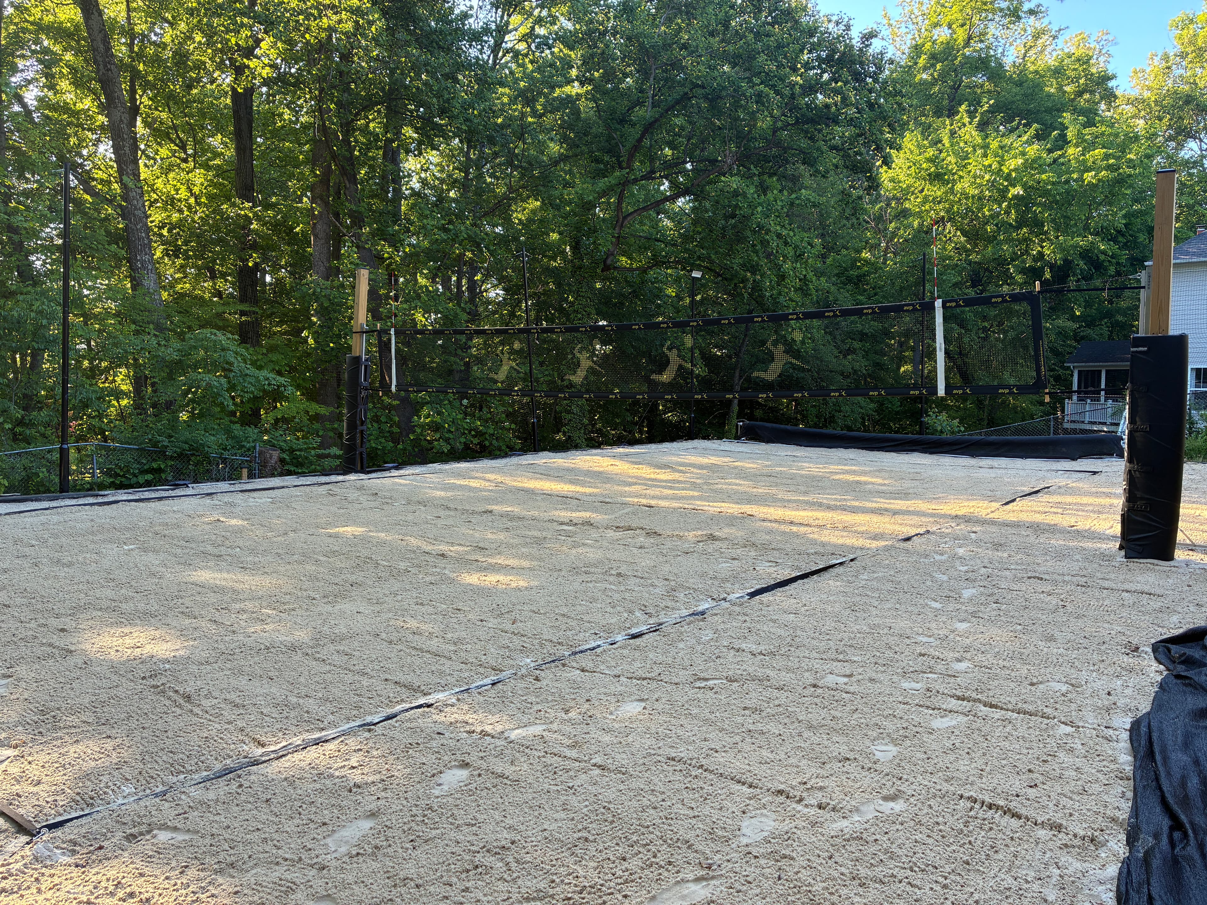 Freshly raked backyard sand volleyball court